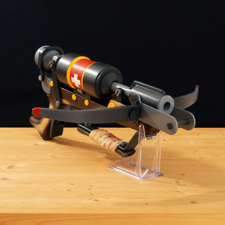 A TF2 Medic Crusader's Crossbow prop for cosplay or collection with a removable fake syringe bolt! Has all the little details from in-game like the bloody rag wrapped around the front wooden handle or small scuff all around.
