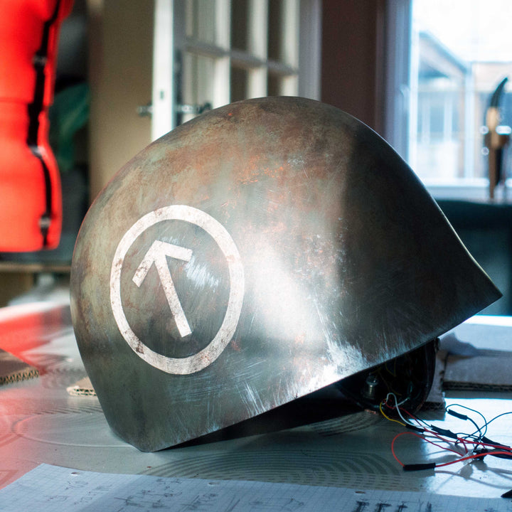 An Inspired Fallout New Vegas 2 parts helmet featuring the well knows NCR Ranger Helmet function. Lenses glow no matter the light, and it has side lights on the right side controlled at the right ear piece control panel. Has a fan inside to wick out moisture so you can be comfortable while wearing it for extended period of time. inside is padded with vegetable leather and a chin strap for align your vision with the lenses no matter your build. TyrsfalTV logo
