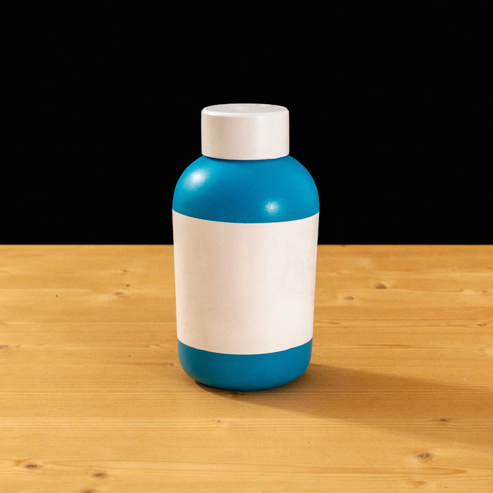 A TF2 Small Health Kit Replica Props for cosplay featuring its blue body, the white cap and white label with a chipped red cross.