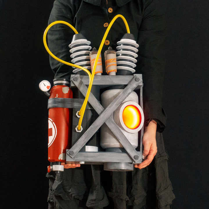 Arkan holding a Team Fortress 2 cosplay prop Quick Fix Backpack from Meet the Real Medic from the red team