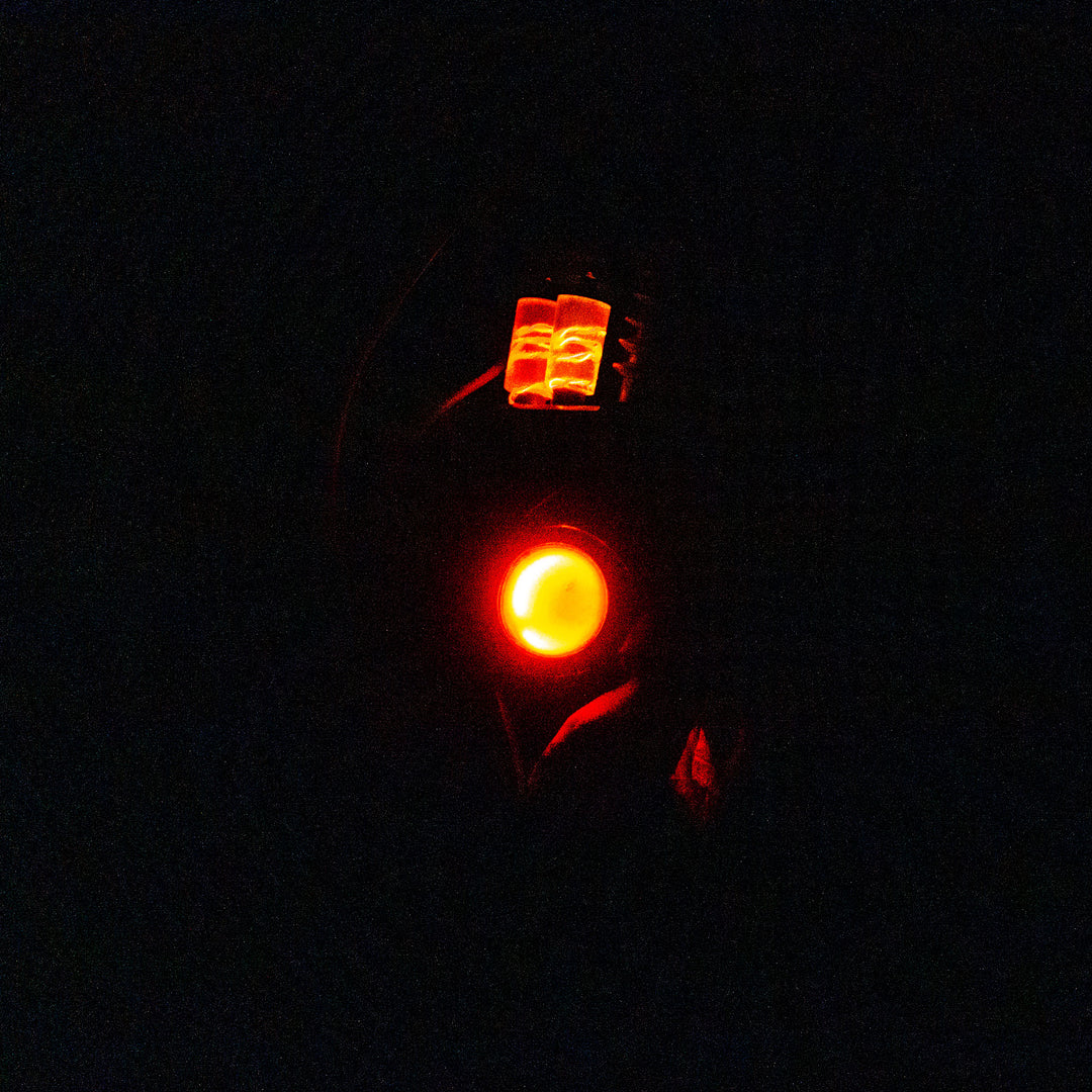 Arkan holding a Team Fortress 2 cosplay prop Quick Fix Backpack from Meet the Real Medic from the red team in the dark