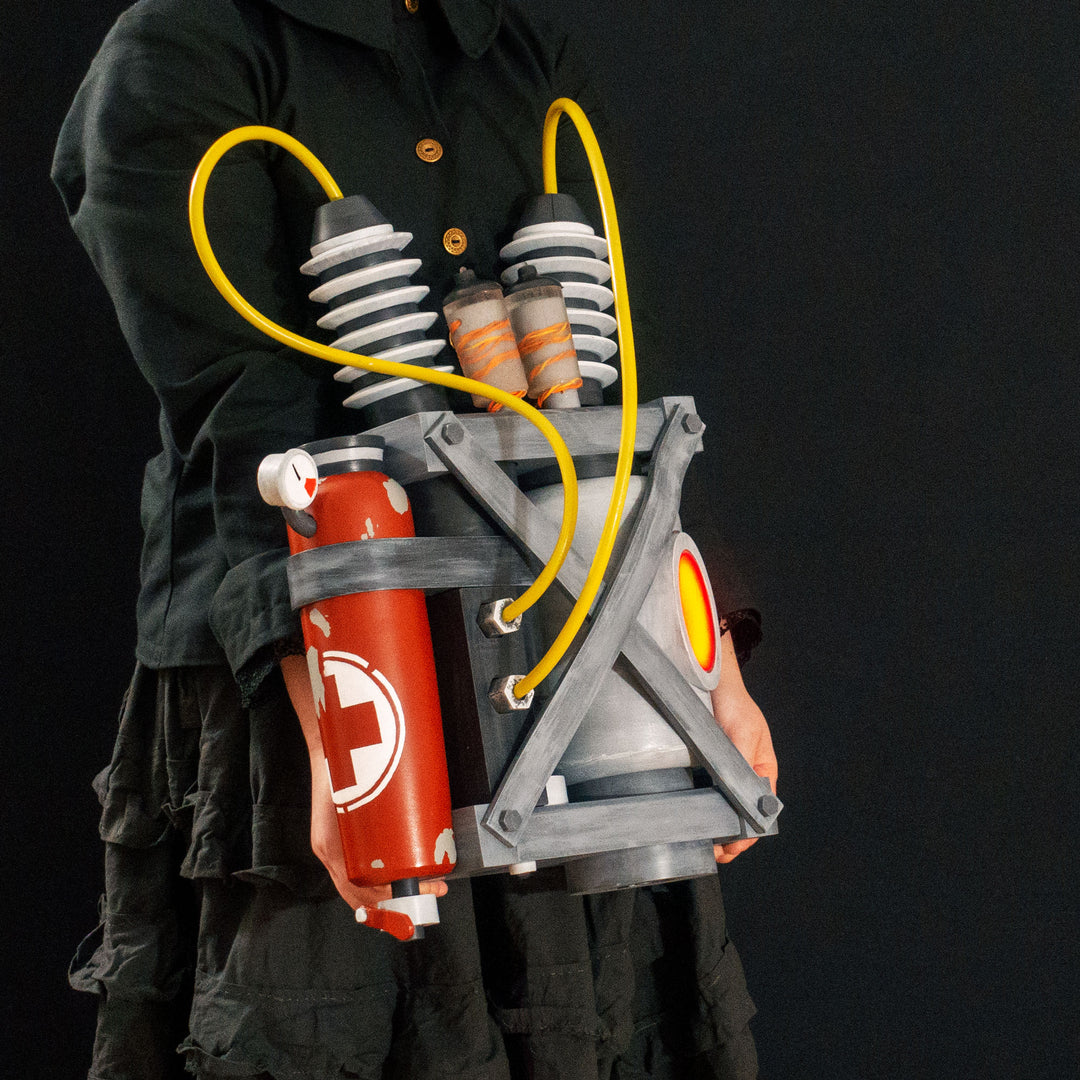 Arkan holding a Team Fortress 2 cosplay prop Quick Fix Backpack from Meet the Real Medic from the red team