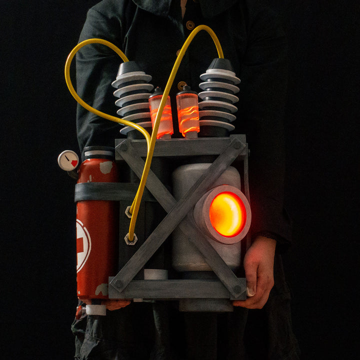 Arkan holding a Team Fortress 2 cosplay prop Quick Fix Backpack from Meet the Real Medic from the red team
